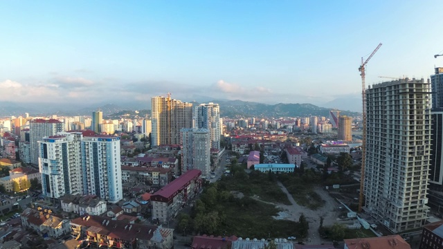 有建筑工地、摩天大楼、交通和山脉的城市空间。间隔拍摄。巴统,格鲁吉亚视频素材