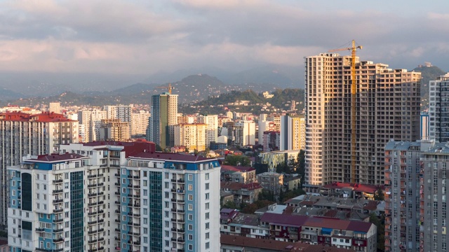 有建筑工地、摩天大楼、交通和山脉的城市空间。间隔拍摄。巴统,格鲁吉亚视频素材