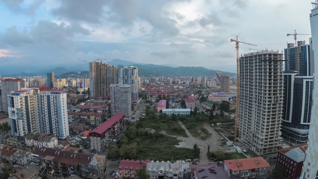 从白天到夜晚的城市空间，建筑工地，摩天大楼，交通和山脉。间隔拍摄。巴统,格鲁吉亚视频素材