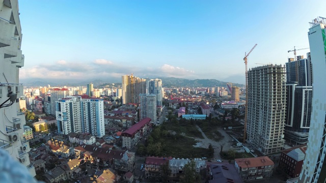 有建筑工地、摩天大楼、交通和山脉的城市空间。间隔拍摄。巴统,格鲁吉亚视频素材