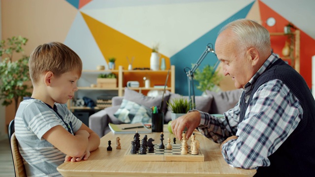 爷爷和孙子在棋盘上下棋视频素材