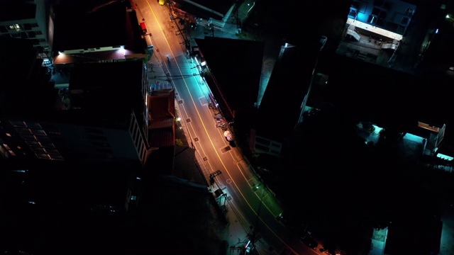 空中夜光照亮了泰国巴通路的城市景观。交通航拍全景。夹。夜晚城市明亮的灯光。踏板车视频素材