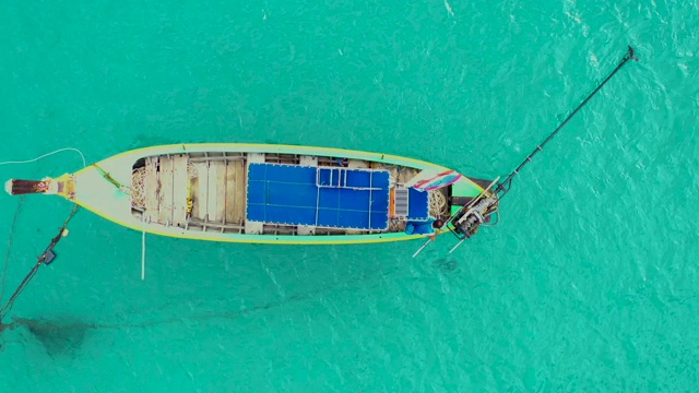 鸟瞰图或俯视图长尾船漂浮在翡翠海上。泰国普吉岛平静的安达曼海。跟踪运动。视频素材