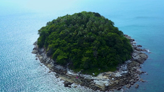 飞向热带岛屿，石质海岸和绿色的森林顶部，棕榈树冠在浓密的杂草丛生的灌木丛中。泰国普吉岛附近的自然风光。Ko聚氨酯视频素材