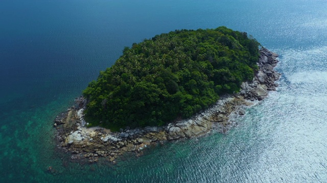 飞向热带岛屿，石质海岸和绿色的森林顶部，棕榈树冠在浓密的杂草丛生的灌木丛中。泰国普吉岛附近的自然风光。Ko聚氨酯视频素材