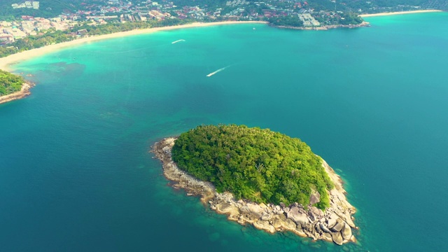 美丽的岩石森林岛，空中全景Ko Pu against山区普吉岛景观为背景。覆盖石岛的热带丛林深处。船航行。空中视频素材