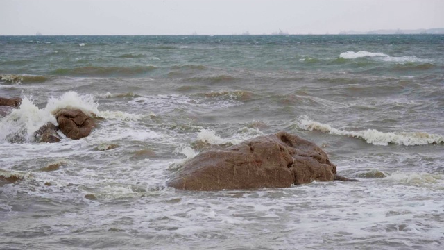 泡沫状的海浪拍打着岩石。视频素材