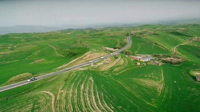 汽车在中国新疆的乡村道路上行驶的鸟瞰图。视频素材