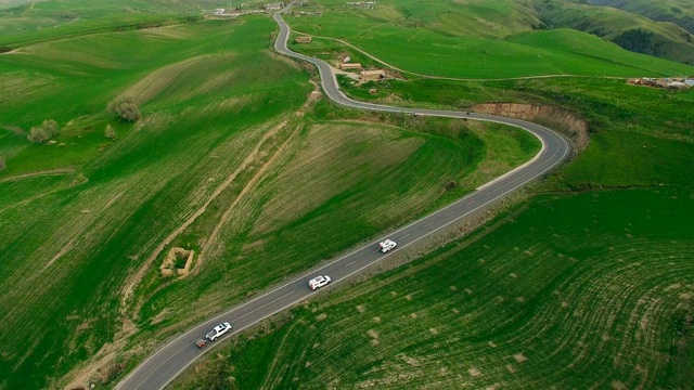 汽车在中国新疆的乡村道路上行驶的鸟瞰图。视频素材