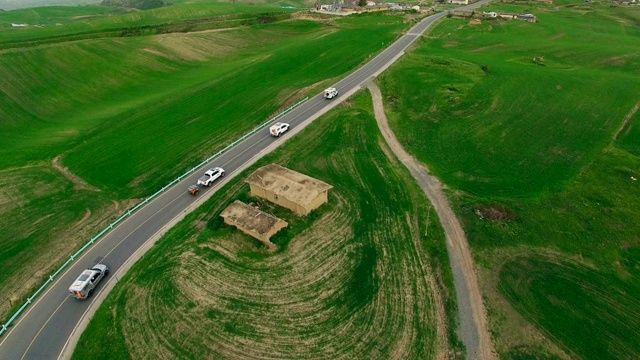 汽车在中国新疆的乡村道路上行驶的鸟瞰图。视频素材