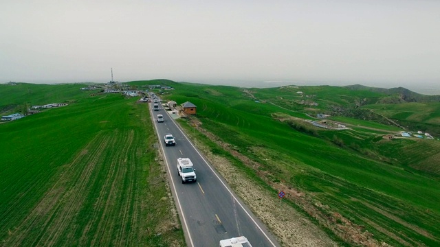 汽车在中国新疆的乡村道路上行驶的鸟瞰图。视频素材