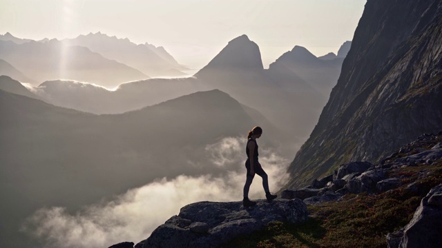 一名妇女在雾中Senja岛的山上徒步旅行视频素材