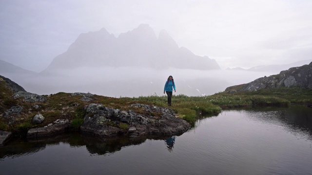 一名妇女在雾中Senja岛的山上徒步旅行视频素材