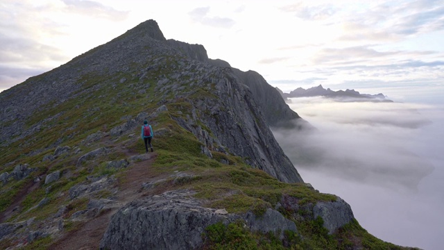 一名妇女在雾中Senja岛的山上徒步旅行视频素材