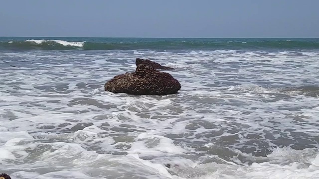 海浪冲击着近岸海面上的巨石。视频素材