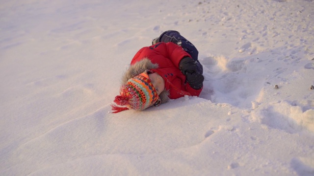 小男孩和他的妈妈在雪里玩。Slowmotion拍摄视频素材