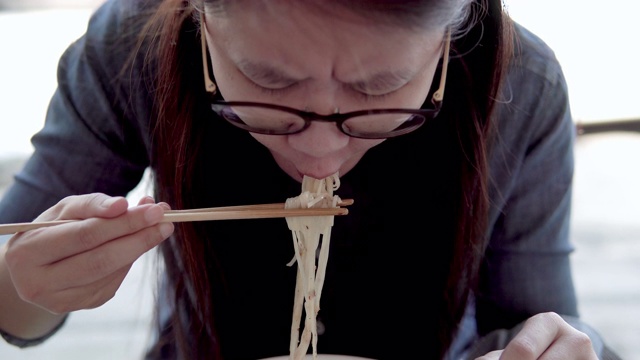 吃面条的亚洲女人。视频素材