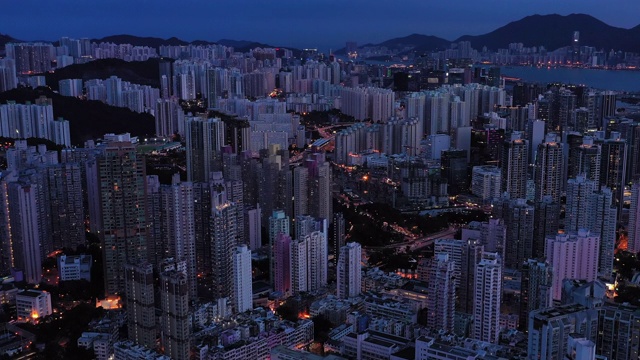 无人机夜间鸟瞰香港城市景观。紧密的空中向前射击飞过办公大楼和摩天大楼。视频素材