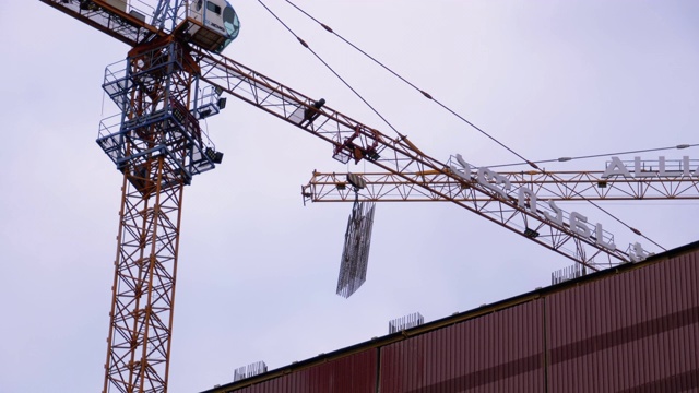 建筑施工。建筑工地上的起重机在吊起货物视频素材