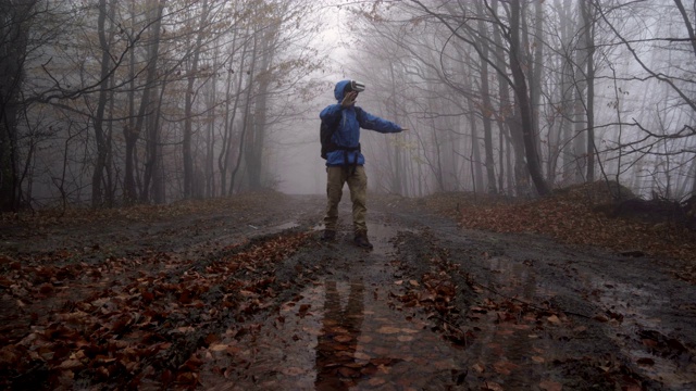 戴着VR眼镜的男人在迷雾密布的雨林里玩游戏，四处游荡视频素材