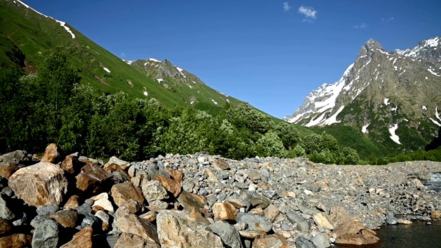 全景慢镜头岩石海岸的暴风雨的山区河流包围了林地和高岩石山脉的高加索。山景观背景视频素材