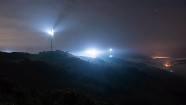 韩国全罗南道花城山/延根郡的夜空和云海与风力涡轮机视频素材