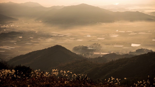 韩国全罗南道，太阳升起时，云海笼罩在Juwolsan山和村庄上/ Boseong-gun视频素材