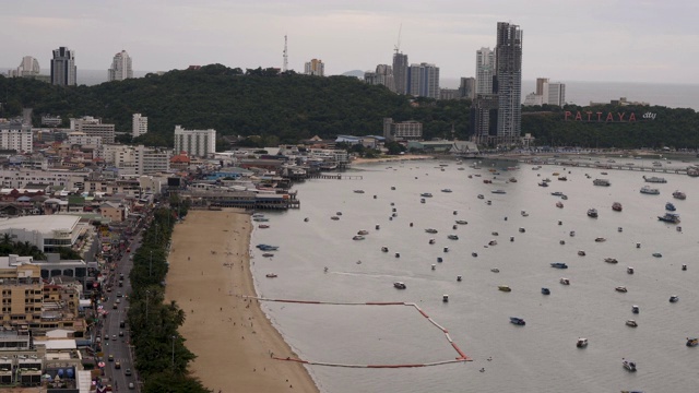 4K T/L时间推移鸟瞰图芭堤雅海滩路天际线和滨水城市景观在泰国。白天拍摄的照片显示了在海滩上的交通，快艇和喷气式飞机在海岸外的海面上行驶。视频素材