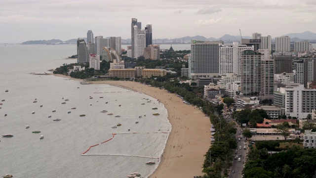 4K T/L时间推移鸟瞰图芭堤雅海滩路天际线和滨水城市景观在泰国。白天拍摄的照片显示了在海滩上的交通，快艇和喷气式飞机在海岸外的海面上行驶。视频素材