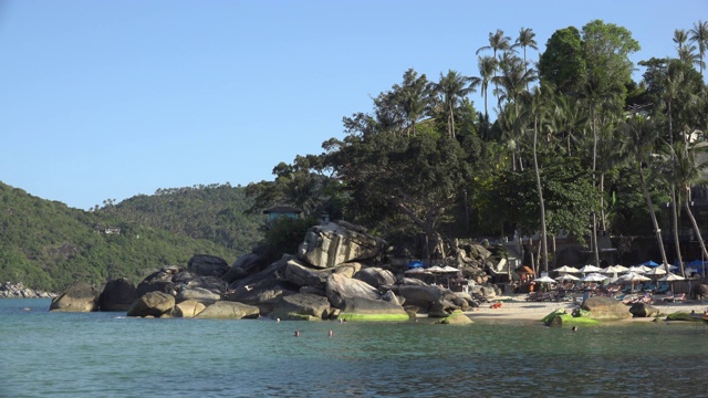 沙滩上的阳伞与岩石形成的海湾视频素材