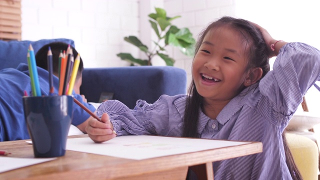 亚洲小女孩用铅笔在纸上画画在家或小学，回到学校和教育理念视频素材