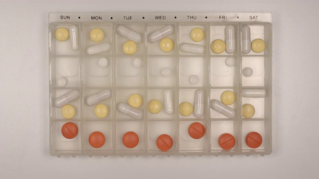 俯视图:许多药丸填满一个塑料组织者在桌子上-停止运动视频素材