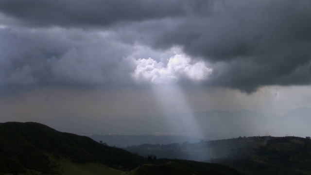 在哥伦比亚坎迪纳马卡山上方，阳光透过暴风雨的云层的鸟瞰图视频素材