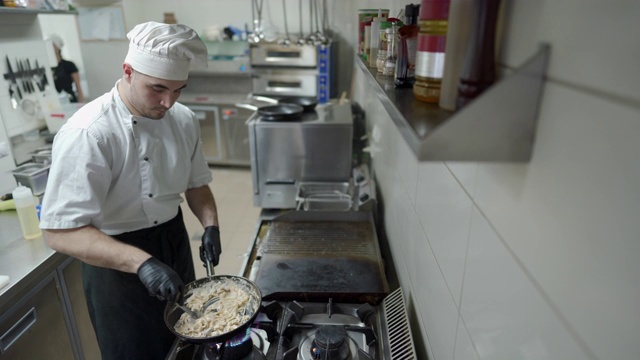 年轻厨师独自在厨房做饭视频素材