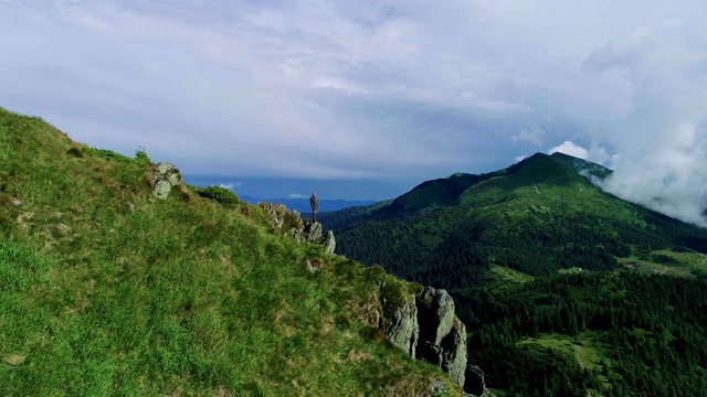 此人站在山崖上，以美丽的风景为背景视频素材