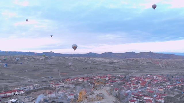 热气球飞过土耳其卡帕多西亚红山谷的鸟瞰图视频素材