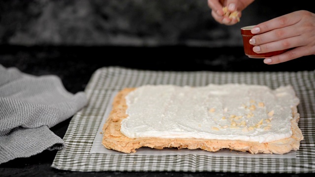 糕点师制作蛋白酥卷蛋糕，在蛋白酥底撒上杏仁。视频素材