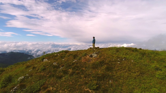 这个人站在有着美丽风景的山上视频素材