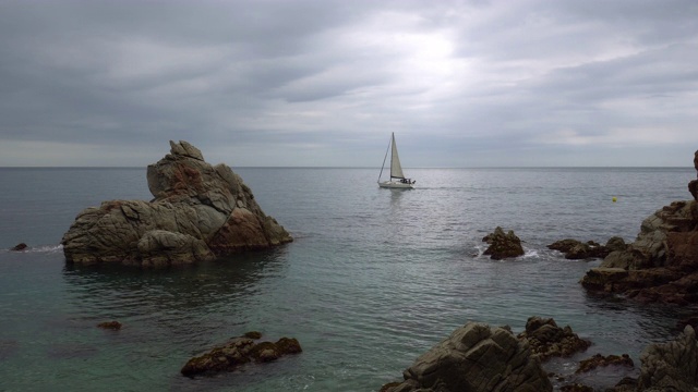 夕阳下，一只孤独的小船在灰色平静的海面上航行。神秘的风景。视频素材