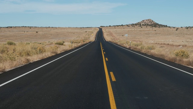 在黑色沥青和黄色线的道路上驾驶在美国沙漠从汽车视频素材