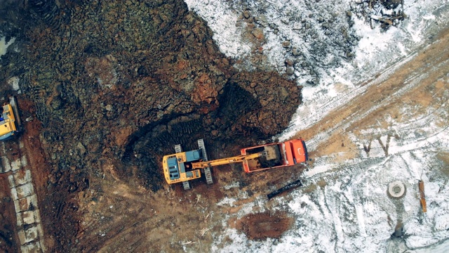 在采石场，建筑机械将石头装载到卡车上。建筑工地的重型机械。工业用拖拉机、挖掘机是工作的职业。视频素材