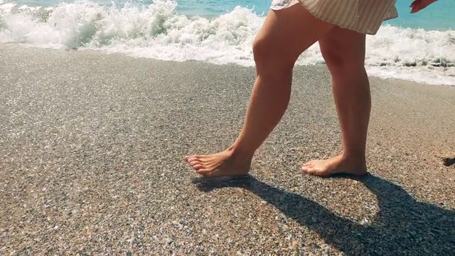 海浪和一个女人走在海边视频素材