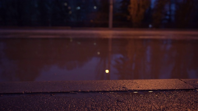 秋季多雨的夜晚城市街道，潮湿的人行道和城市交通道路被淹没视频素材