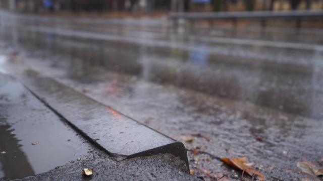 在秋天的雨天，在潮湿的道路上模糊的城市交通。视频素材