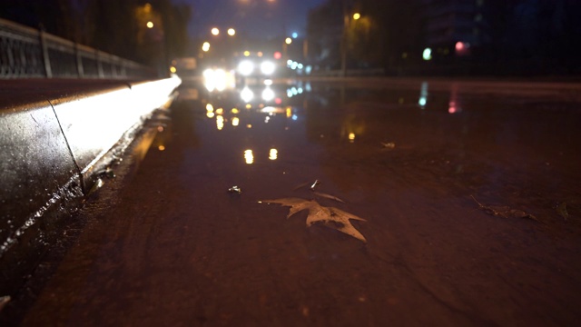 秋雨交加的夜晚，街灯映照在水坑里视频素材