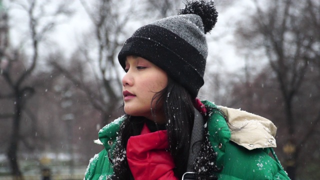 慢镜头:一位年轻女子在圣诞节看着雪花视频素材