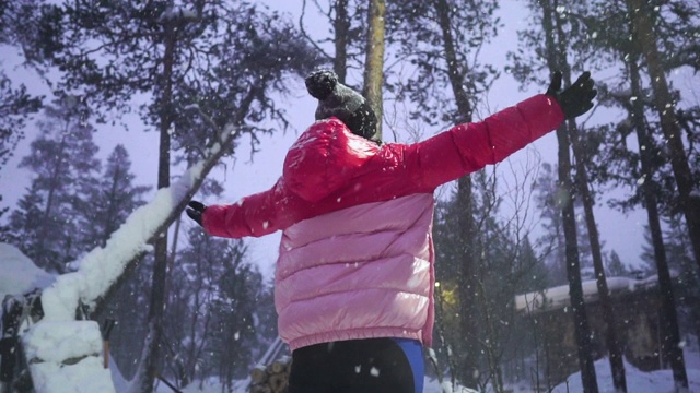 慢镜头:快乐的女人在雪花下玩耍视频素材