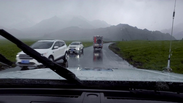 汽车在雨天行驶在山路上，新疆，中国。视频素材