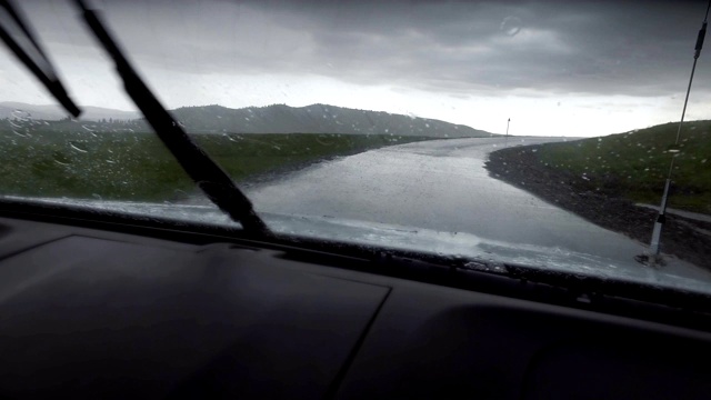 汽车在雨天行驶在山路上，新疆，中国。视频素材