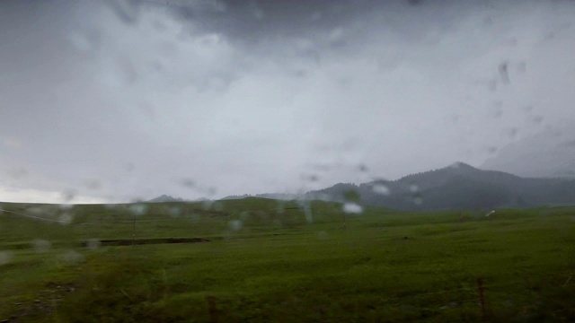 汽车在雨天行驶在山路上，新疆，中国。视频素材